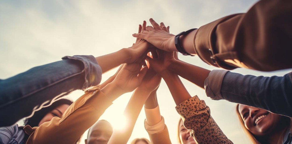multiple people joining hands in the sky